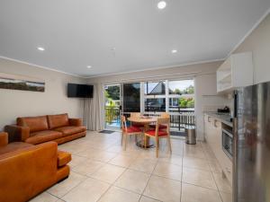 a kitchen and living room with a table and a couch at The Captains Motel in Russell