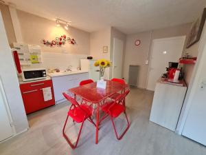 una cucina con tavolo rosso e sedie rosse di Guestroom Choloy-Ménillot, 2 pièces, 4 personnes - FR-1-584-189 a Choloy