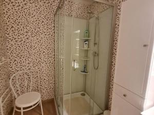 prysznic ze szklanymi drzwiami i stołek w łazience w obiekcie Charmante Chambres d'Hôtes au Cœur des Côtes de Toul, Proche Parc Lorraine & A31 - FR-1-584-189 w mieście Choloy