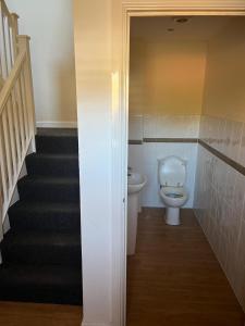 ein Bad mit einem WC und einer Treppe in der Unterkunft A spacious house in Kent in Sittingbourne