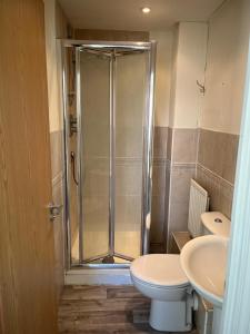 ein Bad mit einer Dusche, einem WC und einem Waschbecken in der Unterkunft A spacious house in Kent in Sittingbourne