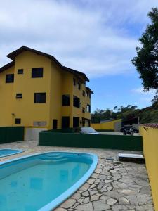 a building and a swimming pool in front of a building at Apartamento Mar Brasil II in Ubatuba
