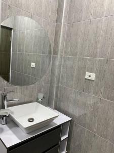 ein Bad mit einem Waschbecken und einem Spiegel in der Unterkunft Apartamento de descanso in La Dorada