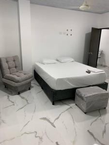 ein Schlafzimmer mit einem Bett und einem Stuhl in der Unterkunft Apartamento de descanso in La Dorada