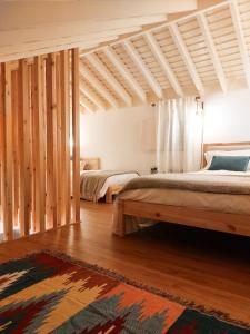 a bedroom with two beds and a rug at Casas da Chaminé Eco Country Lodge in Nordeste