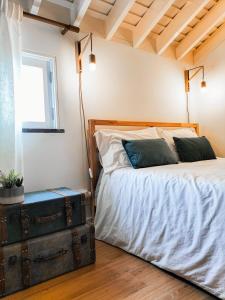 Casas da Chaminé Eco Country Lodge في نوردست: غرفة نوم بسرير وشنطة قديمة