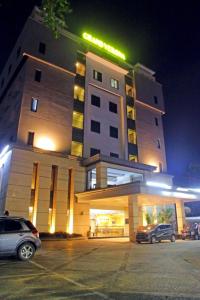 a hotel with cars parked in a parking lot at night at Grand Verona Samarinda in Samarinda