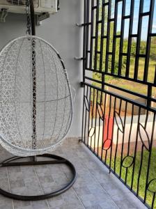 a swinging chair in a room with a window at Stylish apartments in Gaborone