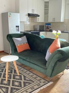 a green couch with pillows on it in a kitchen at Stylish apartments in Gaborone