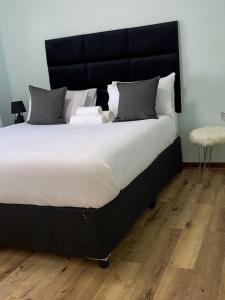 a large bed with a black headboard in a bedroom at Stylish apartments in Gaborone