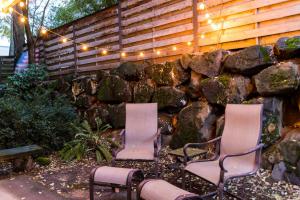 two chairs and a stone wall with lights at King Bed + Studio! Free Parking, Patio, WFH Space! in Seattle