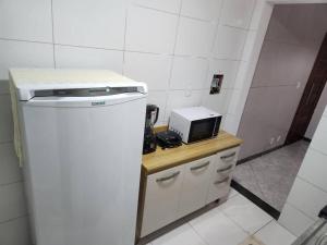 La cocina está equipada con fogones y microondas. en Apartamento perto da Orla de Atalaia, en Aracaju