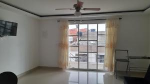 a living room with a ceiling fan and a window at Hermoso apartamento en turbaco in Turbaco