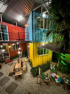 Cette chambre occupe un bâtiment coloré doté d'une table et de chaises. dans l'établissement Container Hospedaria Paraty, à Parati