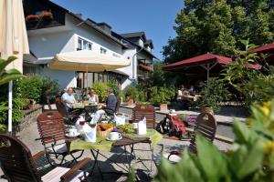 eine Gruppe von Menschen, die an Tischen im Garten sitzen in der Unterkunft Landidyll Hotel Restaurant Birkenhof in Klosterkumbd