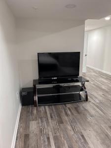 a flat screen tv sitting on a stand in a living room at Luxurious Basement Guest Suite in Elkridge in Elkridge