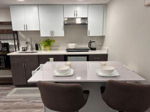 a kitchen with white cabinets and a table with chairs at Luxurious Basement Guest Suite in Elkridge in Elkridge