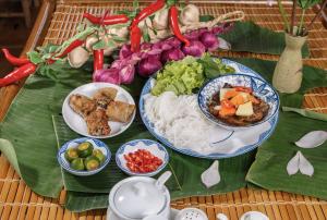 富国Cybele Sunset Hotel Phu Quoc的桌子上放着盛有食物的盘子，放在香蕉叶上