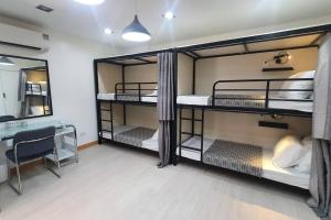 a room with three bunk beds and a desk at Travelers Inn - Cozy Capsule Bunks, Makati in Manila