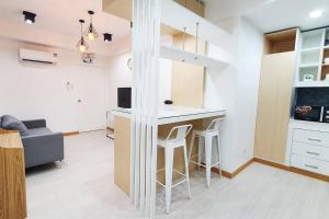 a kitchen with a bar with stools in a room at Travelers Inn - Cozy Capsule Bunks, Makati in Manila