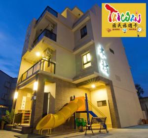 uma casa com um escorrega à frente em 充電樁 羅東木村電梯民宿Luodong Tree BnB 雲朵朵二館 免費洗衣機 烘衣機 星巴克咖啡豆 國旅卡特約店 em Luodong