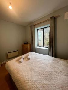 a bedroom with a white bed with a window at The Flat in Temple Bar in Dublin