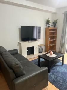 a living room with a couch and a table and a tv at The Flat in Temple Bar in Dublin