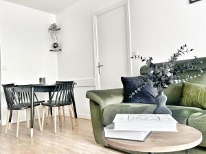 sala de estar con sofá verde y mesa en Appartement proche Roissy CDG, Parc expos de Villepinte, Disneyland, Paris, Astérix, en Le Thillay