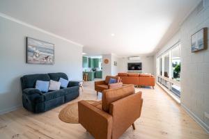 una sala de estar con 2 sofás y sillas. en Island View - 3BR WiFi Encounter Bay Beach, en Encounter Bay