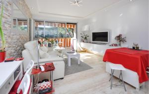 een woonkamer met een witte bank en een rode tafel bij Cozy Apartment In Mandelieu-la-napoule With Outdoor Swimming Pool in Mandelieu-la-Napoule