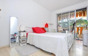 1 dormitorio con cama blanca y ventana grande en Cozy Apartment In Mandelieu-la-napoule With Outdoor Swimming Pool, en Mandelieu-la-Napoule