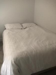 a white bed with white sheets and pillows at Single room in willesden in London