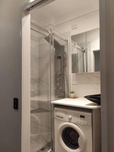 a washing machine in a bathroom with a mirror at Short-long term Private Smart modern studio in Jamboree Heights