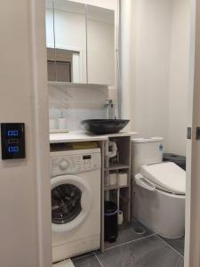 a bathroom with a washing machine and a toilet at Short-long term Private Smart modern studio in Jamboree Heights