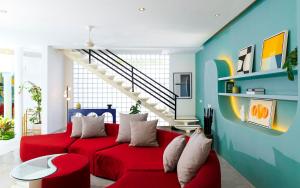 a living room with a red couch and a staircase at Villa Ungava in Seminyak