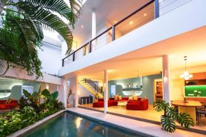 a house with a swimming pool and a living room at Villa Ungava in Seminyak