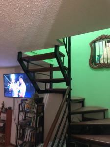escalera con TV en la sala de estar en Tu espacio Re - Cuarto con encanto, en Santiago