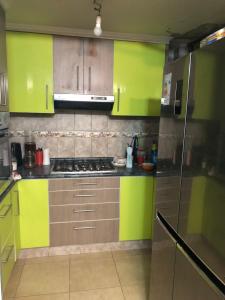 a kitchen with green cabinets and a stove top oven at Tu espacio Re - Cuarto con encanto in Santiago