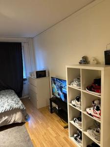 a bedroom with a bed and a shelf with shoes at Comfort zone in Stockholm