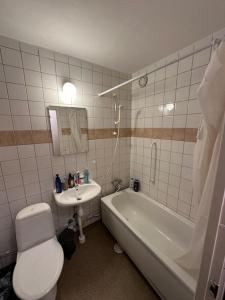 a bathroom with a toilet and a tub and a sink at Comfort zone in Stockholm