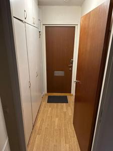 un corridoio con porta marrone e pavimento in legno di Comfort zone a Stoccolma