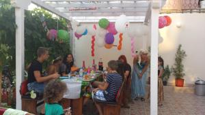 a group of people sitting at a table at a party at Veda Guest House in Pomorie