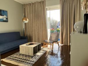 a living room with a blue couch and a table at Ady house in Setúbal