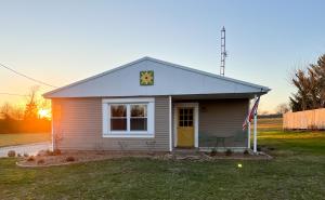 ein kleines Haus mit einer Flagge davor in der Unterkunft The Sunshine Bungalow in Greensburg