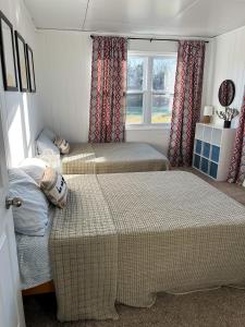 1 Schlafzimmer mit 2 Betten und einem Fenster in der Unterkunft The Sunshine Bungalow in Greensburg