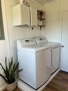 eine Waschmaschine und einen Trockner in einer Waschküche mit einer Anlage in der Unterkunft The Sunshine Bungalow in Greensburg