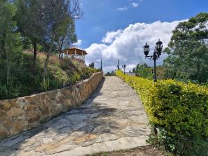 a stone path next to a stone wall with a street light at Hospedaje Resguardo Real in Ráquira