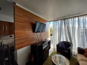 sala de estar con TV de pantalla plana en la pared en Departamento valpo, en Valparaíso