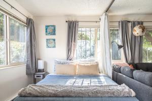 1 dormitorio con cama, sofá y ventanas en Spacious 1 Bed + Studio // Free Parking // Zen Patio, en Seattle