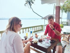 Een man en een vrouw die aan een tafel eten. bij SAGAR BEACH VILLAS in Cherai Beach